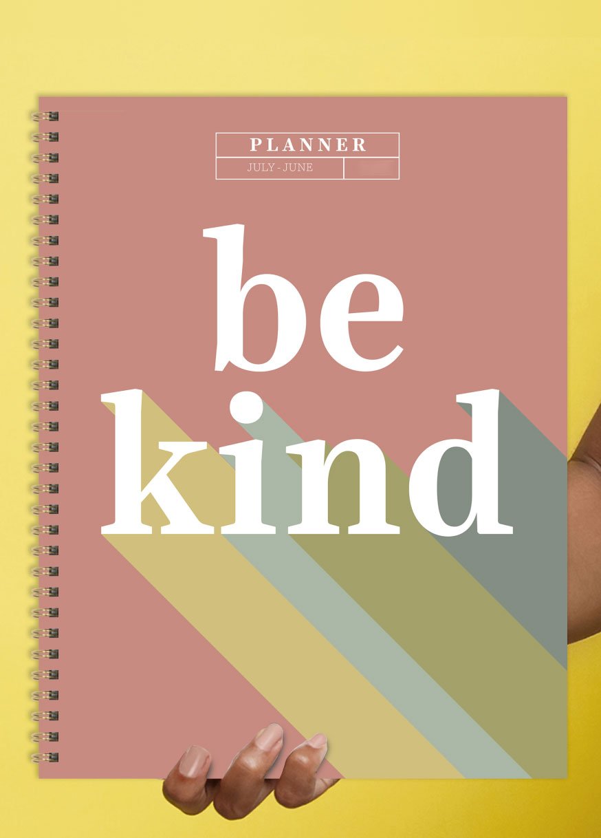 Person holding planner that says Be Kind