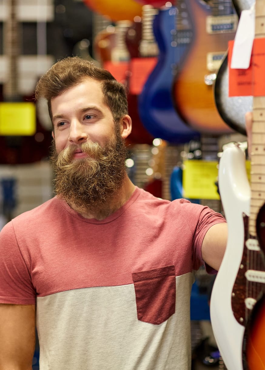 Man picking up instrument in music store