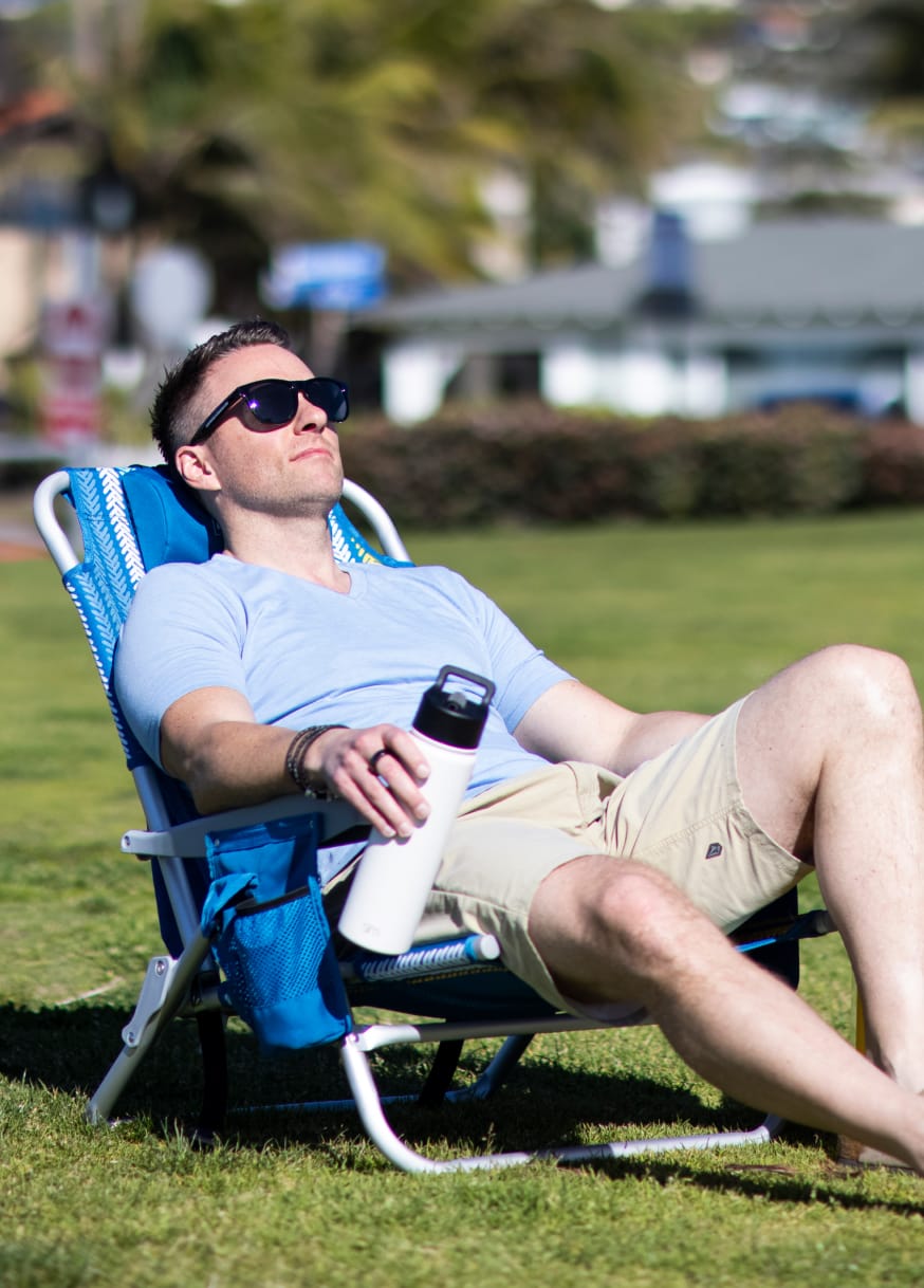 Man relaxing in the sun in Lightspeed Outdoors chair