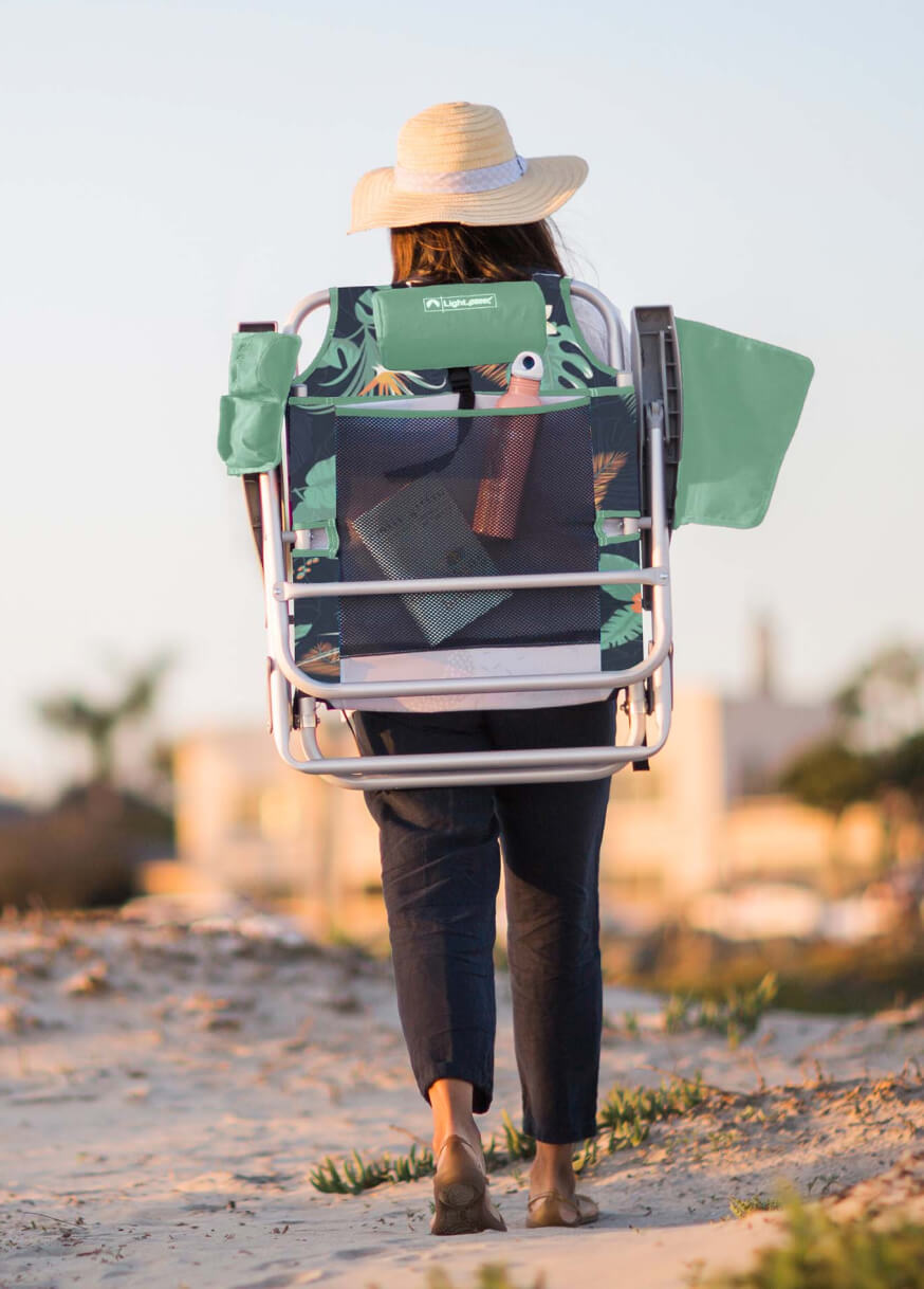 Woman walking on the beach with gear on her back